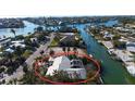 Aerial view showcases the property's waterfront access and lush landscaping in a coastal setting at 607 Baronet Ln, Holmes Beach, FL 34217