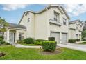 Two-story townhome showing a well-kept lawn, manicured shrubbery, and a private two-car garage at 6330 Green Oak Cir # D, Bradenton, FL 34203