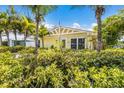 Inviting yellow home with well-manicured landscaping and tropical foliage at 6606 Holmes Blvd # 3, Holmes Beach, FL 34217