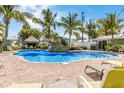 Resort-style pool with waterfall feature surrounded by lush landscaping and lounge chairs at 6606 Holmes Blvd # 3, Holmes Beach, FL 34217