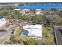 Aerial view of a property with a pool, surrounded by trees, with a waterfront community nearby at 6640 Peacock Rd, Sarasota, FL 34242