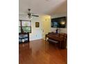 Inviting living room showcasing hardwood floors, a ceiling fan, and a piano at 7109 Java Dr, Sarasota, FL 34241