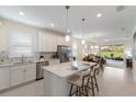 Modern kitchen with white cabinetry, stainless steel appliances, and a spacious island with bar seating at 10470 Spring Tide Way, Parrish, FL 34219