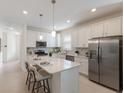 Bright kitchen featuring a large island with bar seating, stainless appliances, and modern finishes at 10470 Spring Tide Way, Parrish, FL 34219