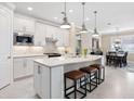 Bright kitchen with white cabinetry, stainless steel appliances, granite countertops, and pendant lighting over the island at 12325 Marsh Pointe Rd, Sarasota, FL 34238
