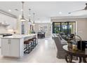 Open-concept kitchen featuring white cabinets, granite countertops, stainless steel appliances, and a breakfast bar with seating at 12325 Marsh Pointe Rd, Sarasota, FL 34238
