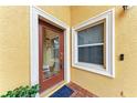 Inviting entryway features a glass door and a window with white trim, set against a textured yellow wall at 1522 3Rd Street E Cir, Palmetto, FL 34221