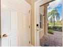 Open foyer area with a view through the glass front door, showcasing the brick-paved pathway and landscaping at 1522 3Rd Street E Cir, Palmetto, FL 34221