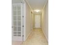 Bright hallway featuring tile floors, neutral walls, and a doorway with a glass paneled door at 167 Maraviya Blvd, Nokomis, FL 34275