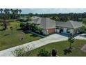 A sprawling single-story home, featuring a large yard, mature trees and a long driveway at 2002 Palm View Rd, Sarasota, FL 34240