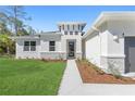 Charming home featuring a well-manicured lawn and a stylish entryway with stone accents at 2157 Snug St, North Port, FL 34286
