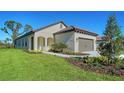 Attractive single-story home features a tile roof, stucco siding, landscaping, and a green lawn at 217 Potenza Loop, North Venice, FL 34275
