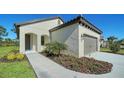 Well-maintained single story home with a tile roof, arched entryway, and attractive landscaping at 217 Potenza Loop, North Venice, FL 34275