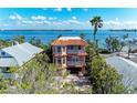 Elegant three-story waterfront home with multiple balconies and a tile roof at 2306 Canasta Dr, Bradenton Beach, FL 34217