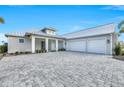 Attractive single-story home featuring an oversized two-car garage and stone paver driveway at 28960 Gin Ln, Punta Gorda, FL 33982