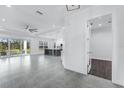 Bright, open-concept living space featuring tile floors, a modern ceiling fan, and large sliding glass doors at 28960 Gin Ln, Punta Gorda, FL 33982