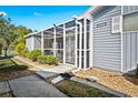 Exterior of home showing siding, a screen enclosed patio, and rock landscaping with walkway to the home's entrance at 3300 Loveland Blvd # 3203, Punta Gorda, FL 33980