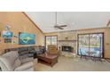 Inviting living room with a stone fireplace, vaulted ceiling, and views of the pool at 3837 Torrey Pines Blvd, Sarasota, FL 34238