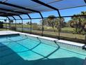 Screened-in pool with tile border overlooks a golf course and water feature for stunning backyard views at 3837 Torrey Pines Blvd, Sarasota, FL 34238