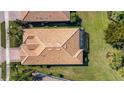 Aerial view of the house with a clay tile roof and a well-manicured lawn at 5946 Caspian Tern Dr, Sarasota, FL 34238