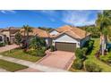 Beautiful single-story home with a tile roof, brick paver driveway, and a well-manicured front lawn at 5946 Caspian Tern Dr, Sarasota, FL 34238