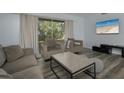 Bright living room with stylish seating, wood-look floors, and backyard views at 2625 Pine Lake Ter # B, Sarasota, FL 34237