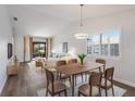 Bright dining area featuring a modern chandelier, a wooden table for six, and an open view to the living room at 2720 60Th Avenue W Dr # D, Bradenton, FL 34207