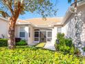 Backyard view of the villa featuring a beautiful landscaped garden, privacy hedges, and a screened in patio at 4155 Cascade Falls Dr, Sarasota, FL 34243