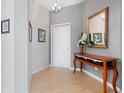 Elegant foyer boasts tile flooring, textured wall, stylish console table with mirror, and decorative lighting at 4155 Cascade Falls Dr, Sarasota, FL 34243