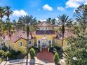 Stunning clubhouse with a red tile roof and an arched entryway surrounded by palm trees at 5552 Bentgrass Dr # 7-116, Sarasota, FL 34235