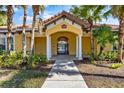 Inviting entrance to community pool area, featuring a yellow building with red tile roof at 5552 Bentgrass Dr # 7-116, Sarasota, FL 34235
