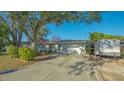 Charming single-story home with a well-maintained lawn, mature tree, and attached garage at 7272 Cass Cir, Sarasota, FL 34231