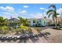 Exterior of a charming beach home that features a gazebo and well-manicured backyard at 912 N Shore Dr, Anna Maria, FL 34216