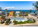 Quaint beach home featuring lush landscaping, and a peek of the ocean at 912 N Shore Dr, Anna Maria, FL 34216