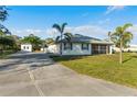 Charming single-story home features a screened lanai, lush lawn, and a long concrete driveway at 222 Pine Glen Ct, Englewood, FL 34223