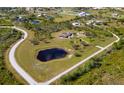 A beautiful property with a house, large yard, detached garage, pond, and a winding road at 25605 69Th E Ave, Myakka City, FL 34251