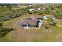 Wide shot of a large estate with a house, detached garage, pergola, and plenty of green space at 25605 69Th E Ave, Myakka City, FL 34251