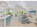 Bright, open living space with vaulted ceilings, coastal decor, light wood floors, and abundant natural light at 418 Magnolia Ave, Anna Maria, FL 34216