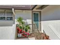 Inviting entrance featuring a well-lit doorway, potted plants, and textured stucco siding at 4234 Gulf Of Mexico Dr # H2, Longboat Key, FL 34228