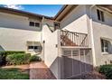 Exterior view of a two-story condo featuring private garage, stucco facade, and brick pathway at 4234 Gulf Of Mexico Dr # H2, Longboat Key, FL 34228