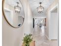 Inviting hallway with tile floors, stylish light fixture, and decorative mirror reflecting the open floorplan at 4518 Pike Ave, Sarasota, FL 34233