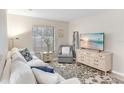 Cozy living room with a plush sofa, modern TV, neutral colors and lots of natural light from the window at 4518 Pike Ave, Sarasota, FL 34233