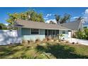 Quaint home exterior showcasing white fencing, light blue siding, mature landscaping, and a concrete driveway at 470 Leach St, Englewood, FL 34223