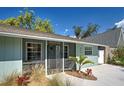 Inviting front entrance with a secure screen door, neat landscaping, and light blue painted siding at 470 Leach St, Englewood, FL 34223