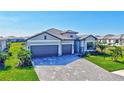 Stunning exterior view of a well-maintained home with a three-car garage and a paver driveway at 4968 Seafoam Trl, Bradenton, FL 34211