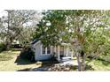 Charming single-story home featuring mature trees and a welcoming front porch with classic column supports at 617 35Th W St, Bradenton, FL 34205