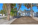 Single-story home with a well-kept lawn, mature trees, and a two-car garage at 710 Birdsong Ln, Sarasota, FL 34242