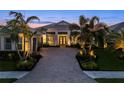 Stunning home exterior featuring a brick driveway, a two-car garage, and lush landscaping at 8271 Redonda Loop, Bradenton, FL 34202