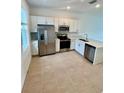 Modern kitchen featuring stainless steel appliances, white cabinetry, and tile flooring at 8949 Daybreak St, Sarasota, FL 34241
