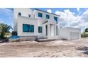 Contemporary two-story home showcasing a pristine white exterior with dark window frames at 927 Contento St, Sarasota, FL 34242